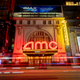An AMC theater in a busy city with bright neon lights